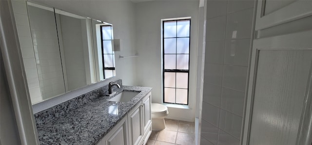 full bathroom with a healthy amount of sunlight, vanity, toilet, and tile patterned floors