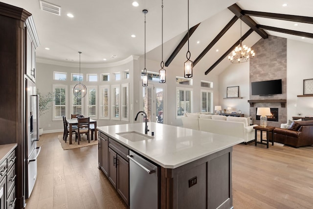 kitchen with pendant lighting, light countertops, a sink, and an inviting chandelier