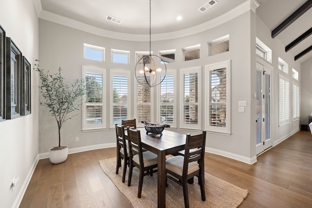 dining area featuring an inviting chandelier, visible vents, baseboards, and wood finished floors