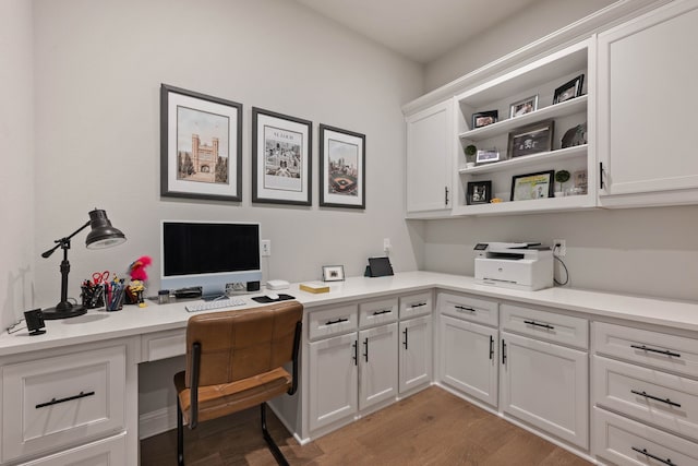 office area featuring light wood-style floors and built in study area