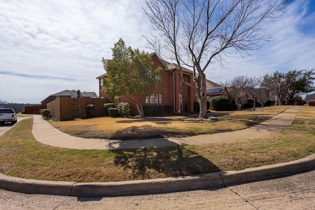 view of side of home with fence and solar panels