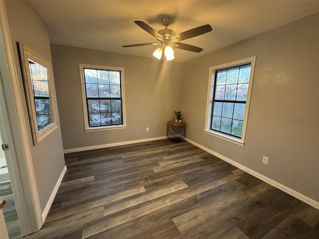 unfurnished room featuring dark wood-style floors, baseboards, and a ceiling fan