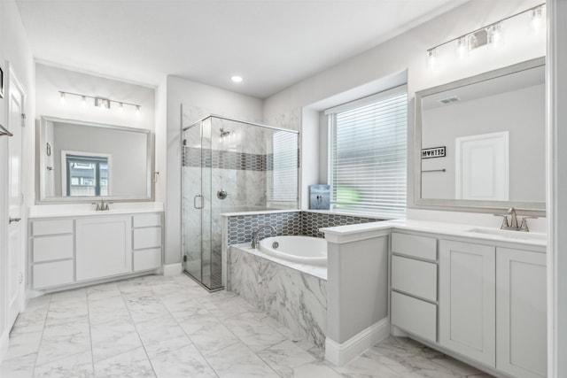 bathroom featuring a sink, marble finish floor, a garden tub, a shower stall, and two vanities