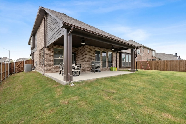 rear view of house featuring brick siding, a yard, a ceiling fan, a patio area, and a fenced backyard