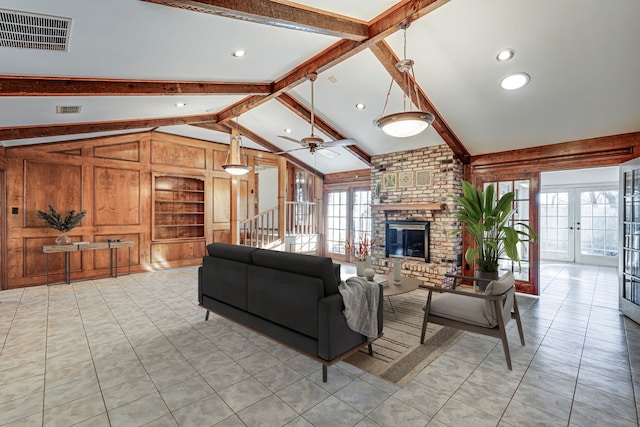 living area featuring french doors, a fireplace, visible vents, lofted ceiling with beams, and wooden walls