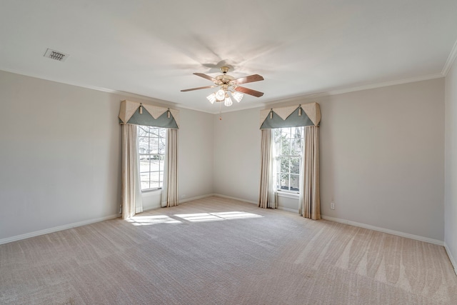 empty room with ornamental molding, visible vents, plenty of natural light, and light carpet