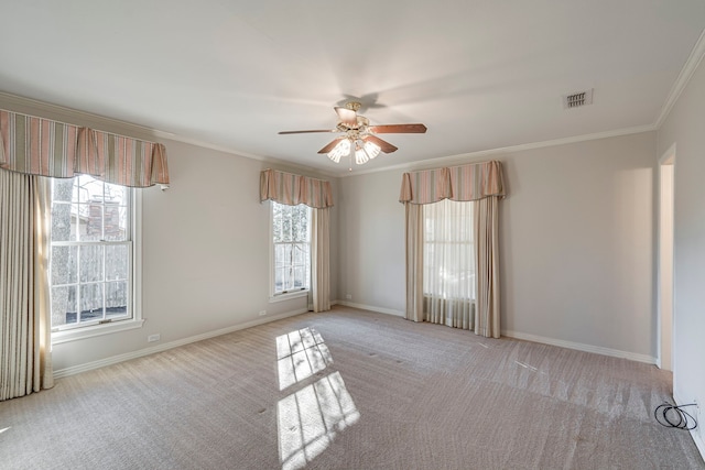 spare room with light carpet, crown molding, and baseboards