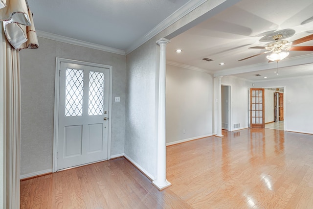 entryway with ornamental molding, light wood-style flooring, and ornate columns