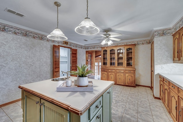 kitchen with a sink, green cabinets, light countertops, a center island with sink, and wallpapered walls