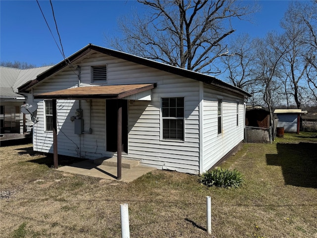 bungalow featuring a patio, a front yard, and fence