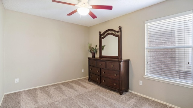 bedroom featuring light colored carpet, baseboards, and ceiling fan