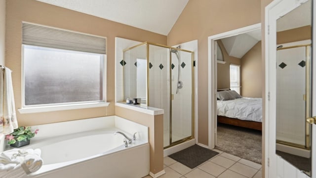 ensuite bathroom with vaulted ceiling, tile patterned floors, a shower stall, and a garden tub