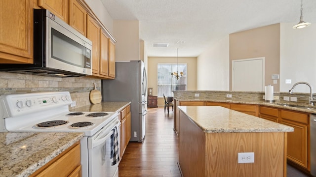 kitchen with visible vents, a sink, appliances with stainless steel finishes, backsplash, and a center island