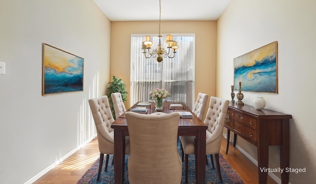dining area featuring a chandelier, wood finished floors, and baseboards