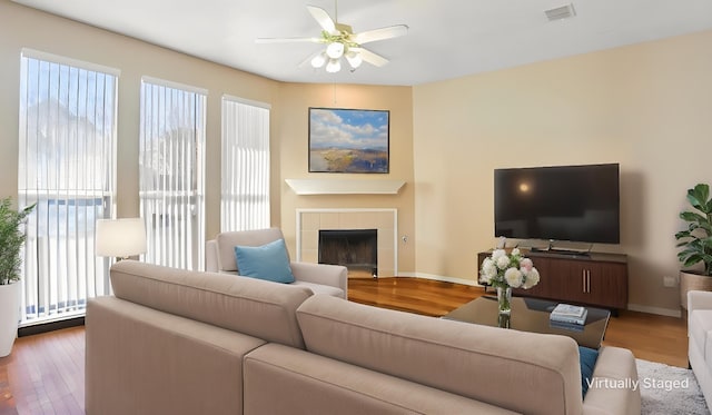 living room featuring a ceiling fan, plenty of natural light, and wood finished floors