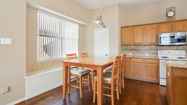 dining space with plenty of natural light, dark wood-type flooring, and baseboards