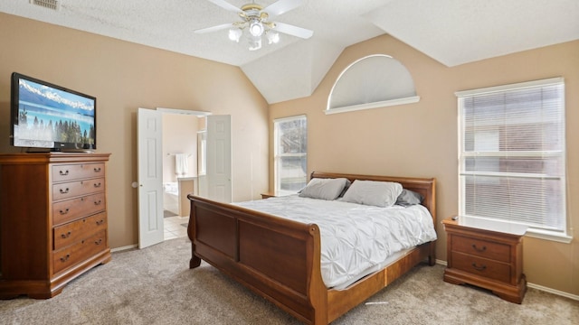 bedroom with light carpet, vaulted ceiling, baseboards, ensuite bathroom, and a ceiling fan