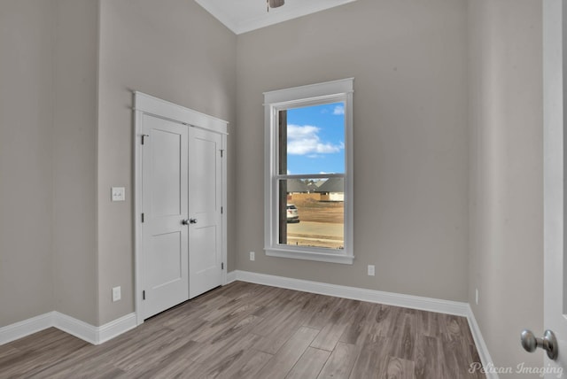 unfurnished bedroom featuring baseboards, a closet, and light wood-style floors