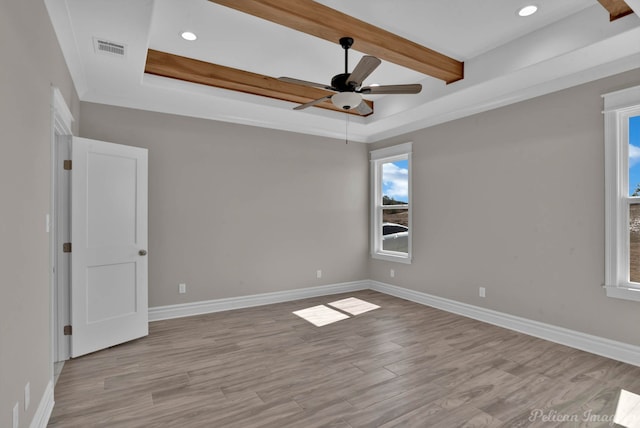 spare room with baseboards, visible vents, light wood-style flooring, and beamed ceiling