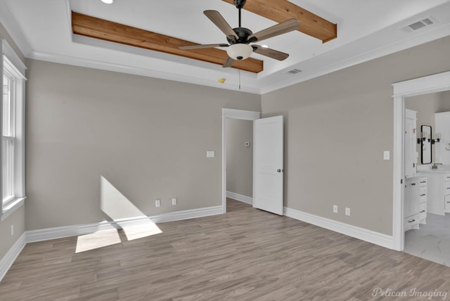 unfurnished bedroom featuring light wood finished floors, baseboards, visible vents, a raised ceiling, and crown molding