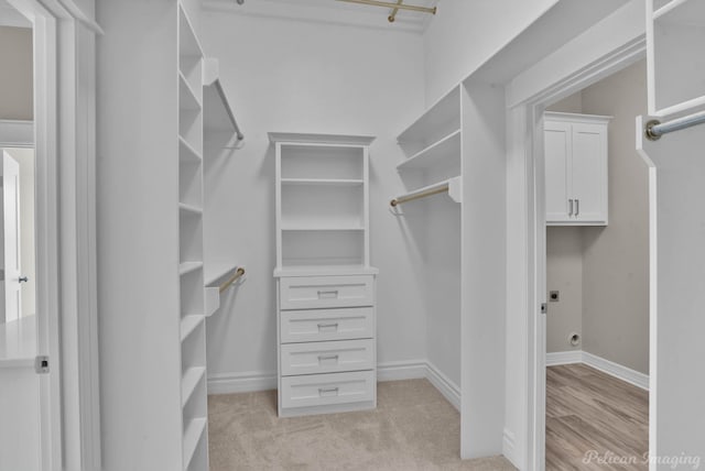 walk in closet featuring light colored carpet