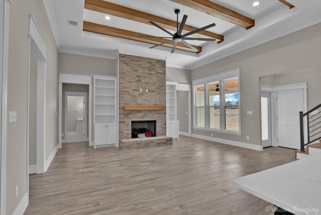 living area with a fireplace, stairway, ceiling fan, light wood-type flooring, and baseboards