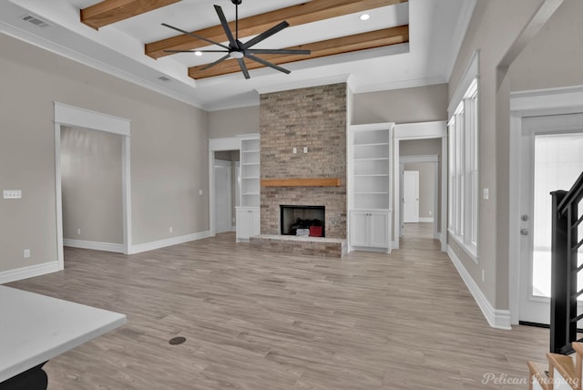 unfurnished living room with light wood-type flooring, a brick fireplace, baseboards, and beam ceiling