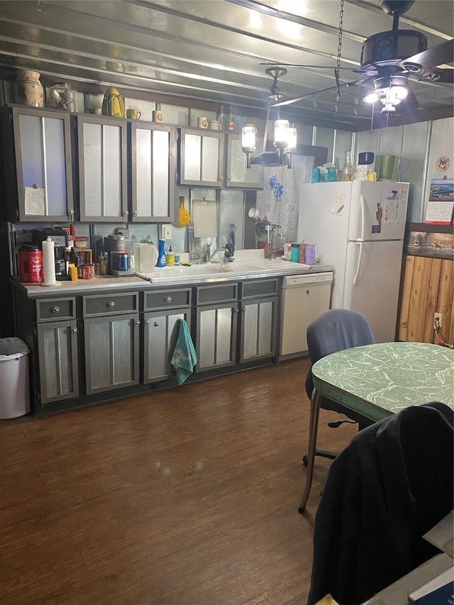 kitchen featuring white appliances, dark wood-style floors, pendant lighting, and light countertops