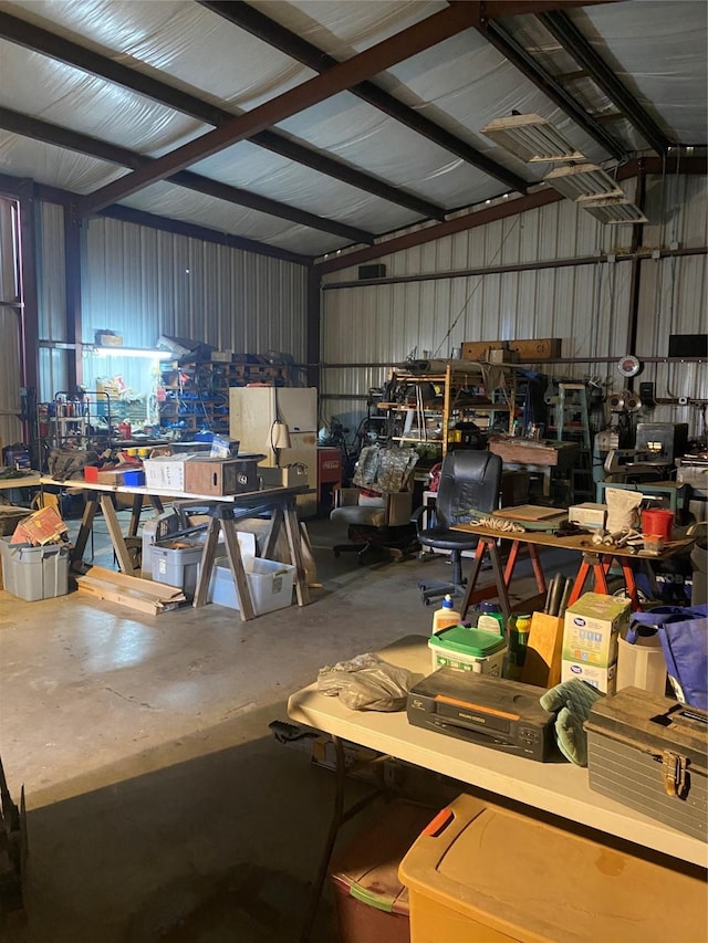 garage with metal wall, a workshop area, and freestanding refrigerator