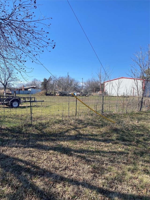 view of yard with a rural view and fence