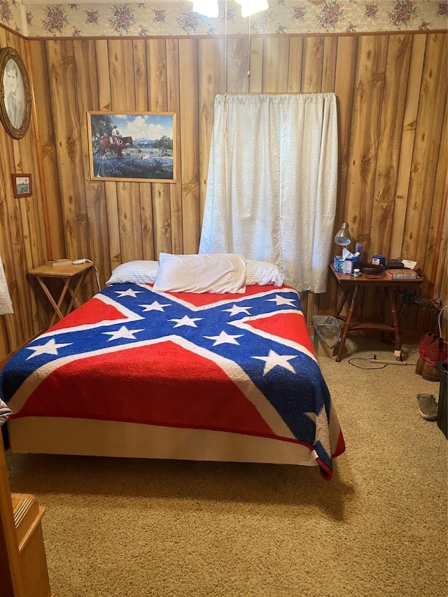 bedroom featuring wood walls, carpet flooring, and wallpapered walls