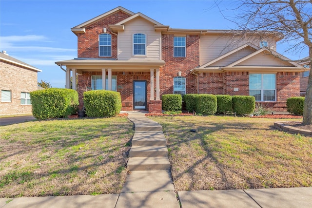 traditional home featuring a front yard and brick siding