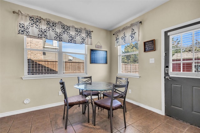 tiled dining room featuring baseboards