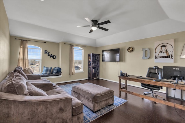 living area with baseboards, vaulted ceiling, a ceiling fan, and wood finished floors