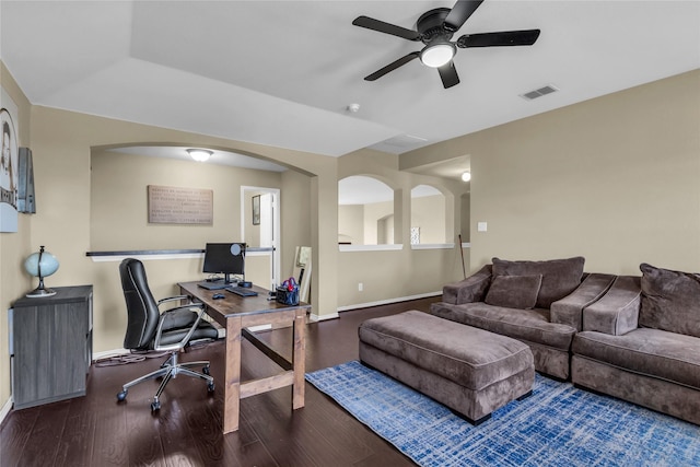 home office with ceiling fan, wood finished floors, visible vents, and baseboards