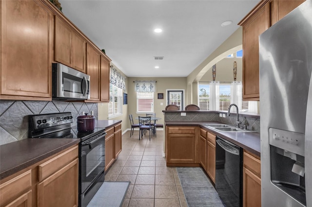 kitchen featuring black appliances, dark countertops, a sink, and visible vents