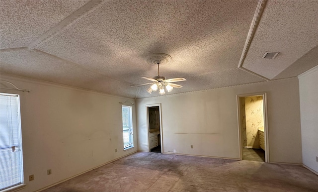 unfurnished bedroom featuring a textured ceiling, carpet floors, ornamental molding, and visible vents