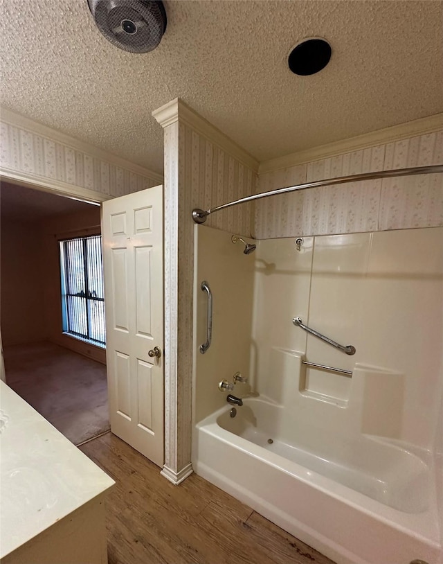 full bathroom with a textured ceiling, ornamental molding, wood finished floors, and wallpapered walls