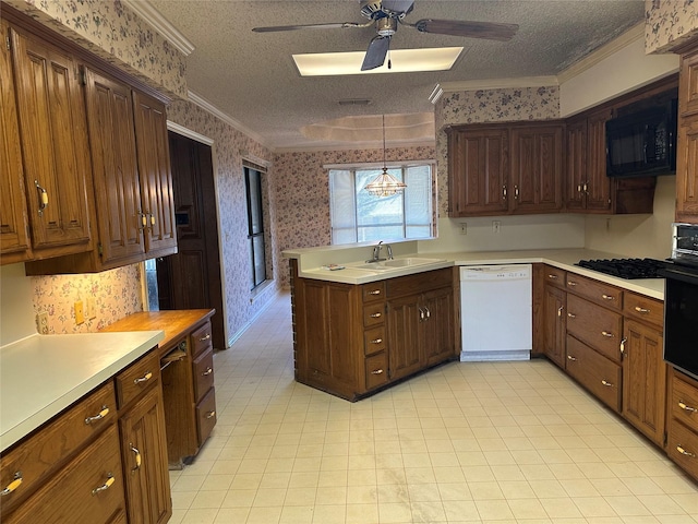 kitchen with wallpapered walls, light countertops, ornamental molding, black appliances, and pendant lighting