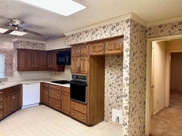 kitchen featuring black appliances, crown molding, light countertops, and wallpapered walls