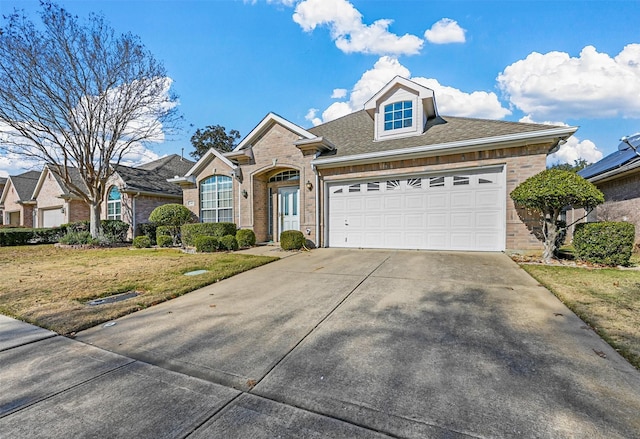 view of front of home with a garage, brick siding, a shingled roof, driveway, and a front lawn