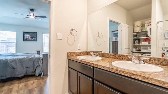 full bath featuring double vanity, wood finished floors, a sink, and ensuite bathroom