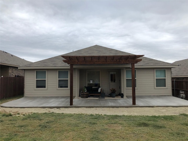 rear view of house with a yard, fence, and a patio