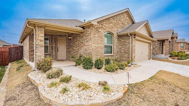 single story home with brick siding, roof with shingles, concrete driveway, fence, and a garage