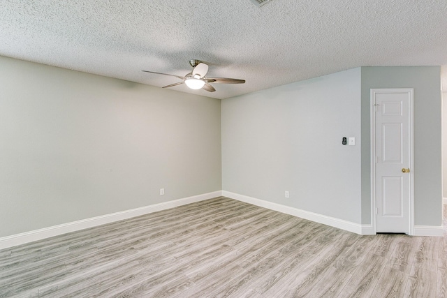 empty room featuring ceiling fan, light wood finished floors, a textured ceiling, and baseboards