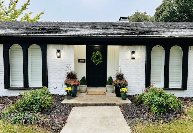 view of exterior entry featuring brick siding