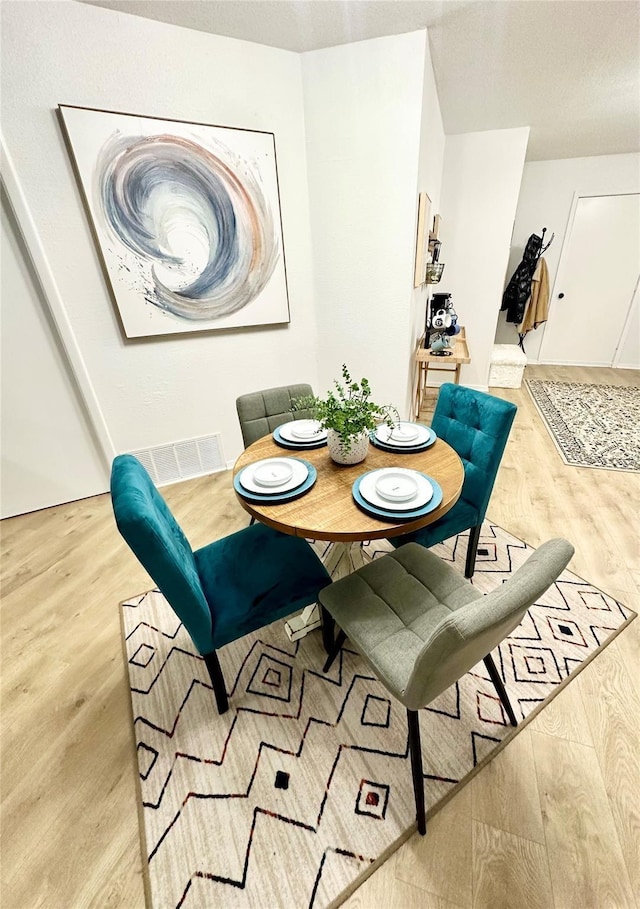 dining area with visible vents and light wood-style flooring