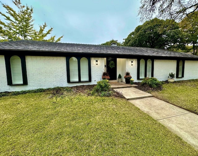 view of front of home featuring a front lawn and brick siding