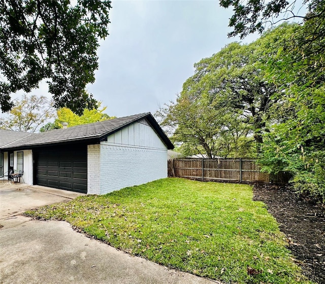 view of property exterior featuring an attached garage, a yard, fence, and brick siding