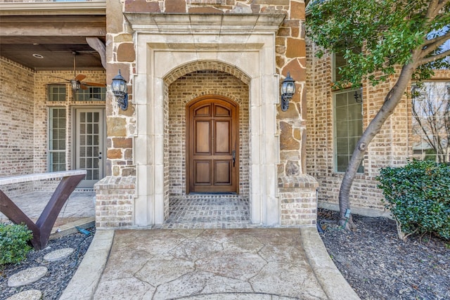 view of exterior entry featuring stone siding and brick siding